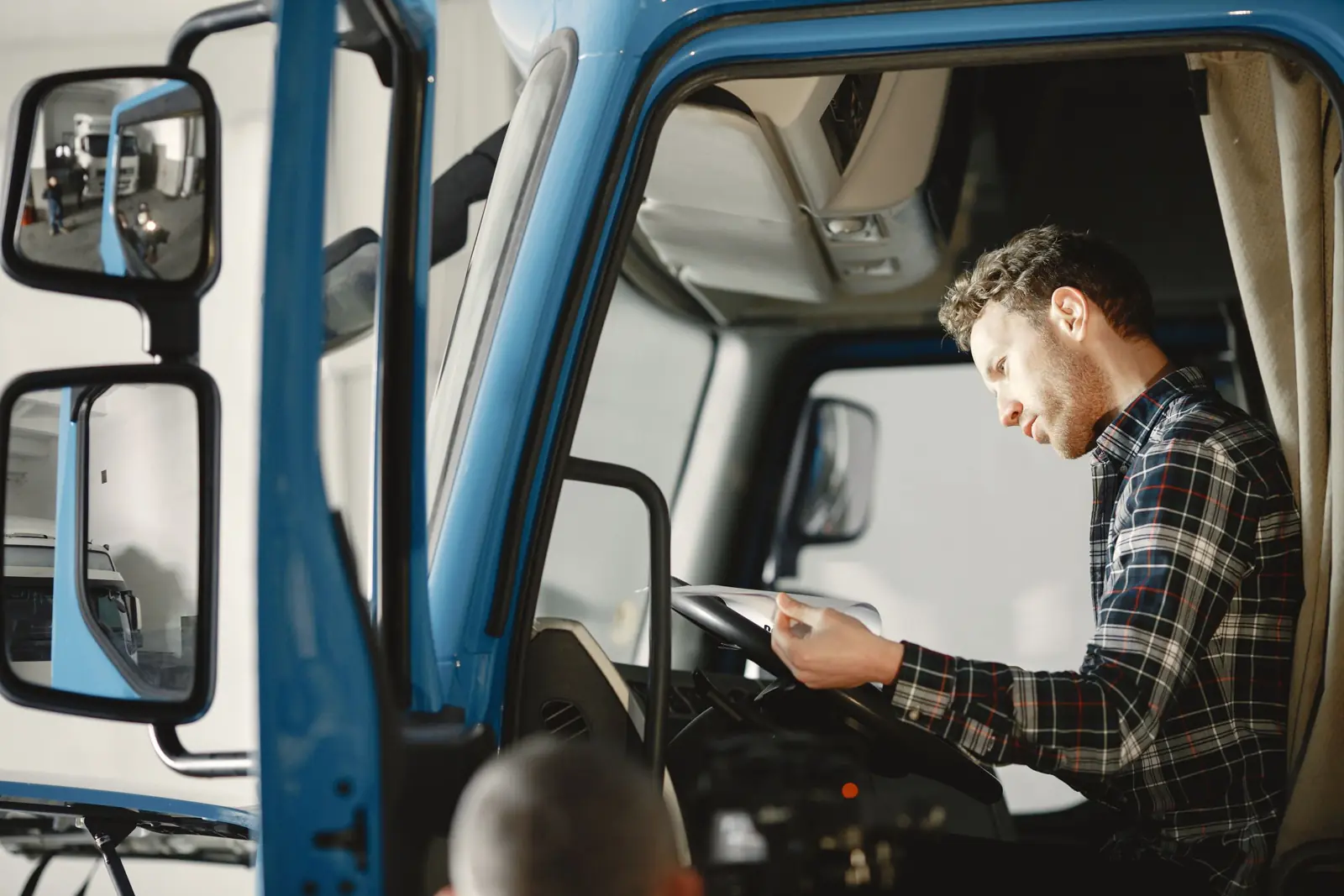 Șofer în cabina camionului, citind actele cursei